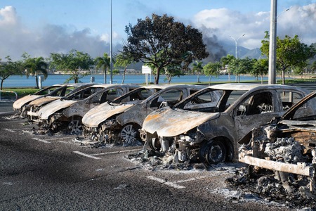 போராட்டத்தின்போது எரிக்கப்பட்ட காா்கள்.