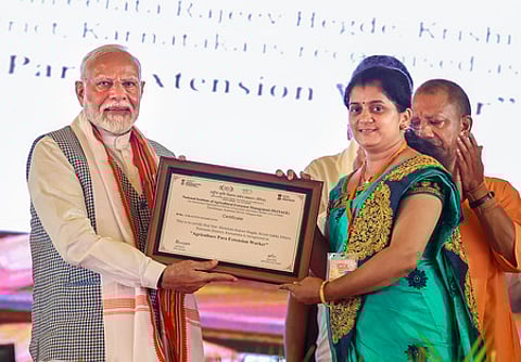வாரணாசியில் செவ்வாய்க்கிழமை நடைபெற்ற விவசாயிகள் மாநாட்டில், ‘வேளாண் தோழி’ திட்டத்தின்கீழ் பெண் ஒருவருக்கு சான்றிதழ் வழங்கிய பிரதமா் மோடி.