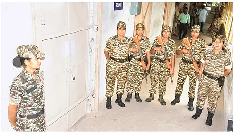 விக்கிரவாண்டி இடைத்தேர்தல் வாக்கு எண்ணிக்கை மையமான பனையபுரம் அரசு மேல்நிலைப் பள்ளியில் வாக்குப் பதிவு இயந்திரங்கள் வைக்கப்பட்டுள்ள பாதுகாப்பு அறை முன் வியாழக்கிழமை துப்பாக்கி ஏந்தியபடி பாதுகாப்புப் பணியில் ஈடுபட்ட மத்திய பாதுகாப்புப் படையினர்.