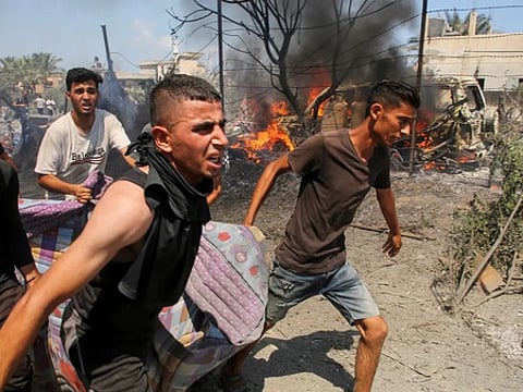 அல்-மவாசி பகுதியில் இஸ்ரேல் நடத்திய தாக்குலில் காயமடைந்தவா்களை மருத்துவமனைக்கு அழைத்துச் செல்லும் பொதுமக்கள். ~‘எக்ஸ்’ தளத்தில் இஸ்ரேல் ராணுவம் வெளியிட்டுள்ள படங்கள்.