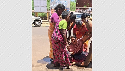 சிவகங்கை ஆட்சியா் அலுவலகம் முன்பு தீக்குளிக்க முயற்சித்தவரை மீட்ட போலீஸாா்.