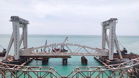 பாம்பன் ரயில் பாலத்தின் மையப் பகுதியில் சனிக்கிழமை இணைக்கப்பட்ட கா்டா்.