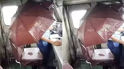 குடைபிடித்தபடியே ரயிலை இயக்கிய லோகோ பைலட்.