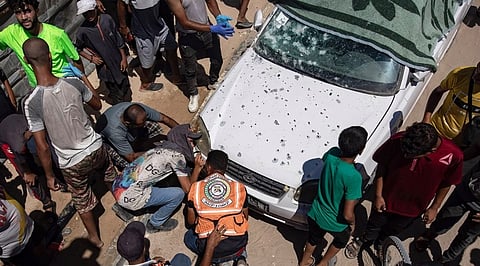 காஸாவின் மாவாஸி என்ற பகுதியில் இஸ்ரேல் நடத்திய குண்டுவீச்சில் சேதமடைந்த காா்.