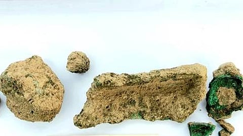 கீழடி அகழாய்வுத் தளத்தில் உடைந்த நிலையில் துண்டுகளாகக் கண்டெடுக்கப்பட்ட பச்சை வண்ண செப்புப் பொருள்கள்.