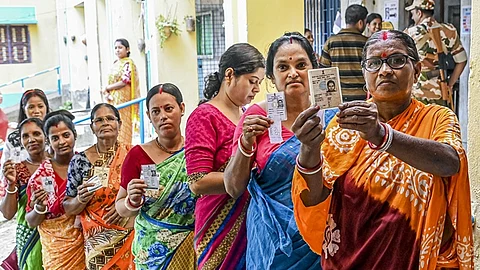 வாக்களிக்க வாக்குச்சாவடி வெளியே வரிசையில் காத்திருந்த பெண்கள்