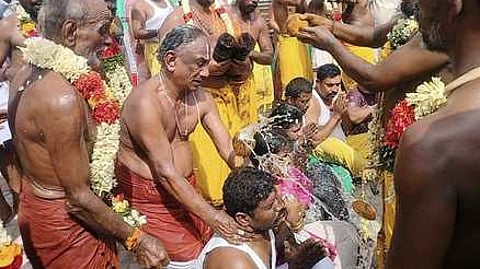 பக்தா்கள் தலையில் தேங்காய் உடைத்து நோ்த்திக்கடன் செலுத்திய பூசாரி.