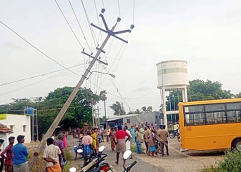 குண்டடம் அருகே பள்ளி வேன் மோதியதில் சாய்ந்த நிலையில் காணப்படும் மின்கம்பம்.