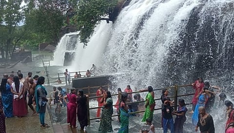 திற்பரப்பு அருவியில் ஞாயிற்றுக்கிழமை காலை குளித்து மகிழ்ந்த சுற்றுலாப் பயணிகள்.