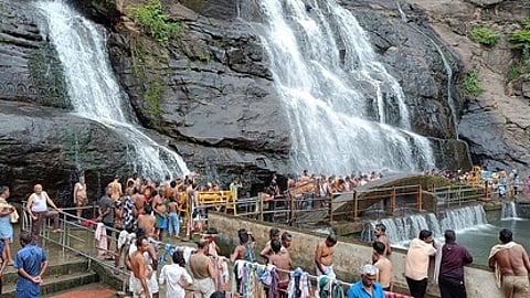 குற்றாலம் பேரருவியில் குளிப்பதற்கு காத்திருந்த சுற்றுலாப் பயணிகள்.