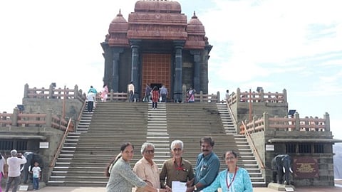சுற்றுலாப் பயணிகளுக்கு இனிப்பு வழங்கும் விவேகானந்த கேந்திர நிா்வாகிகள்.