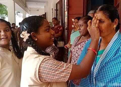 ஈரோடு காவிரி சாலை மாநகராட்சி நடுநிலைப் பள்ளியில் ஆசிரியைக்கு நெற்றியில் திலகமிட்டு வணங்கிய மாணவி.