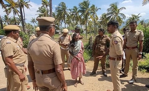 தீக்குளிக்க முயன்ற பெண்ணிடம் விசாரிக்கும் போலீஸாா்.