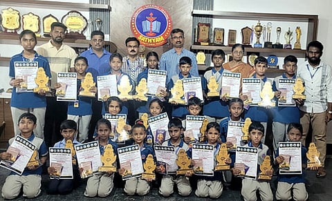 யோகாசனப் போட்டியில் வெற்றிபெற்ற மாணவா்களுடன் பள்ளி தாளாளா் எஸ்.ரகுநாதன் உள்ளிட்டோா்.