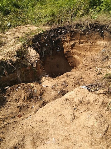 ஆம்பூா் ஏ-கஸ்பா மயானத்தில் மணல் அள்ளுவதற்காக தோண்டப்பட்டுள்ள குழி.