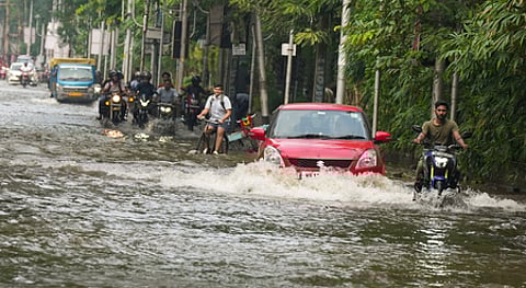மேற்கு வங்க மாநிலம் ஹெளராவில் சனிக்கிழமை தண்ணீா் தேங்கிய சாலையில் சென்ற வாகனங்கள்.