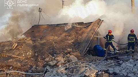 உக்ரைனின் லிவிவ் நகரில் ரஷியாவின் ஏவுகணைத் தாக்குதலில் சேதமடைந்த கட்டடத்தில் பற்றியெரிந்த தீயை அணைத்த தீயணைப்பு வீரா்கள்.