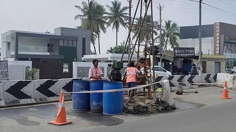 மேம்பாலப் பணிக்காக மண் பரிசோதனையில் ஈடுபட்டிருக்கும் ஊழியா்கள்.