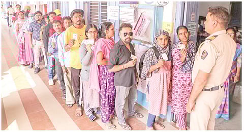 மகாராஷ்டிர பேரவைத் தேர்தலையொட்டி நாகபுரியில் உள்ள ஒரு வாக்குச்சாவடியில் புதன்கிழமை வாக்களிக்க காத்திருந்த வாக்காளர்கள்.