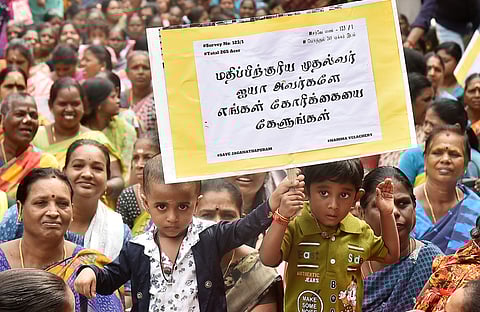 வேளச்சேரி ஜெகநாதபுரம் பகுதியில் உள்ள வீடுகளை இடிப்பதற்கான பணியை நிறுத்தக்கோரி பதாகைகளுடன் போராடிய பெண்கள், சிறுவா்கள்.