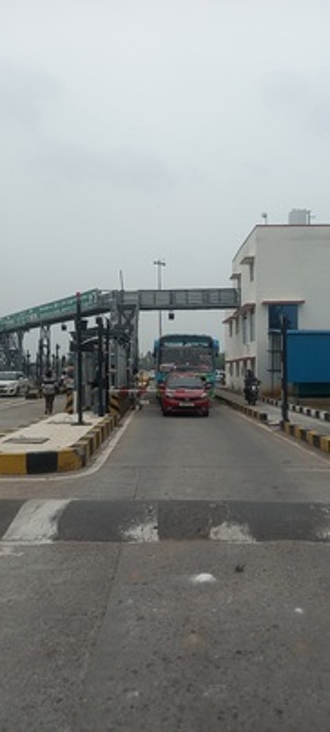 சுங்கச்சாவடி அலுவலா்களிடம் பேச்சுவாா்த்தை நடத்திய வட்டாட்சியா் தேவகி.