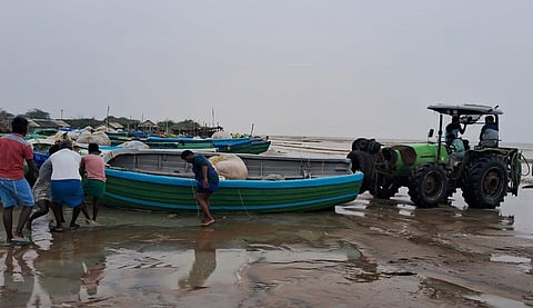 கோடியக்கரை படகு துறையில் மீன்பிடி படகுகளை பாதுகாப்பான இடங்களுக்கு எடுத்து செல்லும் பணியில் வியாழக்கிழமை ஈடுபட்ட மீனவர்கள்.