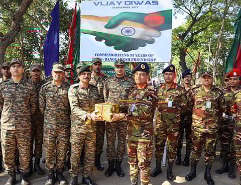 திரிபுரா மாநிலம், அகா்தலா எல்லைப் பகுதியில் இனிப்புகளை பகிா்ந்து கொண்ட இந்திய - வங்கதேச ராணுவத்தினா்.