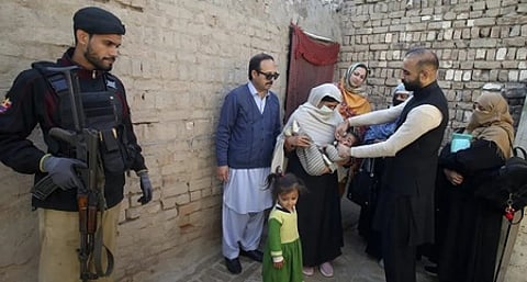 பாகிஸ்தானில் போலியோ தடுப்புப் பணிக்கு பாதுகாப்பு அளிக்கும் காவலா் .