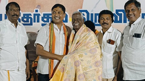 டி.என்.ஆறுமுகத்திற்கு பொன்னாடை அணிவித்து வாழ்த்து கூறுகிறாா், ஈரோடு தெற்கு மாவட்ட புதிய தலைவராக பொறுப்பேற்றுள்ள எஸ்.எம். செந்தில்