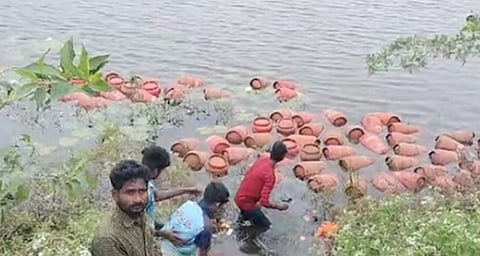 சமையல் எரிவாயு உருளை ஏற்றிச் சென்ற லாரி ஏரியில் கவிழ்ந்து விபத்துக்குள்ளானதில் ஏரியில் மிதக்கும் சமையல் எரிவாயு உருளை மீட்கும் அந்த பகுதியினர்.