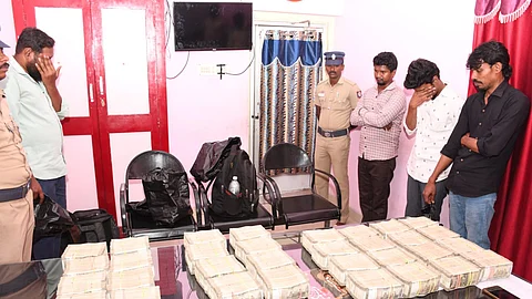 விழுப்புரம் புதிய பேருந்து நிலையத்தில் வியாழக்கிழமை பறிமுதல் செய்யப்பட்ட ரூ.1.60 கோடி பணத்துடன் பிடிபட்ட நான்கு பேர்.