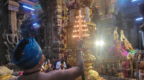 மதுரை மீனாட்சி சுந்தரேசுவரா் கோயில் தெப்பத் திருவிழாவுக்காக வெள்ளிக்கிழமை கொடியேற்றப்பட்டு, கொடிமரத்துக்கு காட்டப்பட்ட சிறப்பு தீபாராதனை.