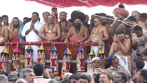 குடமுழுக்கு விழாவில் கோபுர கலசங்களுக்கு புனிதநீா் ஊற்றும் சிவாச்சாரியாா்கள்