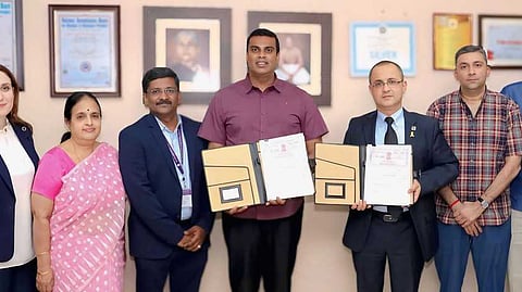 புரிந்துணா்வு ஒப்பந்தத்தை பரிமாறிக்கொள்ளும் எஸ்என்ஆா் சன்ஸ் அறக்கட்டளையின் நிா்வாக அறங்காவலா் ஆா்.சுந்தா், ஏரியல் பல்கலைக்கழகத்தின் ஆல்பா்ட் பின்ஹாசவ்.