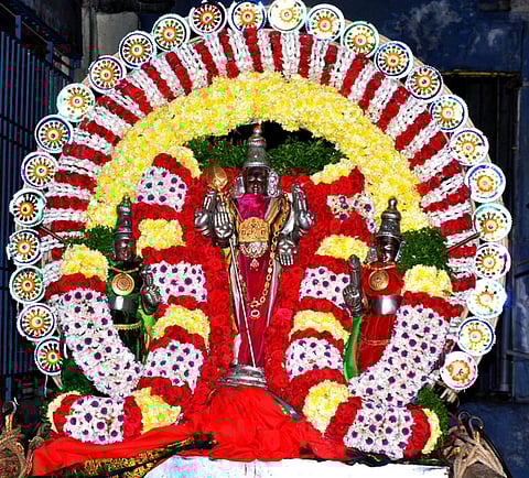 திருத்தணி முருகன் கோயிலில் நடைபெற்ற மாசிப் பெருவிழா கொடியேற்றம். (வலது) விழாவையொட்டி மலா் அலங்காரத்தில் காட்சியளித்த வள்ளி, தெய்வானை சமேத உற்சவா் முருகப் பெருமான்.