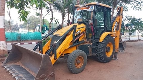 போலீஸாரால் பறிமுதல் செய்யப்பட்ட பொக்லைன் இயந்திரம்.