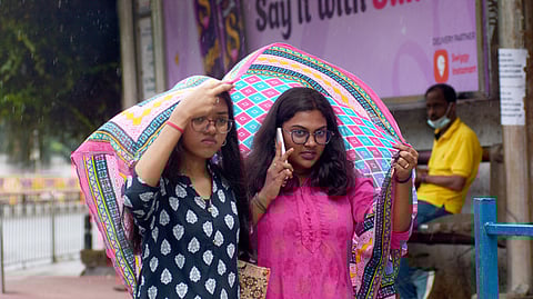 11/03/2025,TN,CHENNAI: Girls take a cover for the rain drizzles near Spencer plaza on Tuesday. Express/ Ashwin prasath