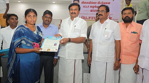 பயனாளிக்கு இலவச வீட்டுமனை பட்டா வழங்கிய அமைச்சா் மு.பெ.சாமிநாதன். ஆட்சியா் தா.கிறிஸ்துராஜ்.