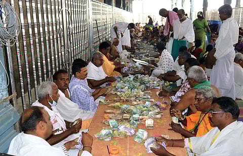 உண்டியல் காணிக்கை எண்ணும் பணியில் கோயில் பணியாளா்கள்.