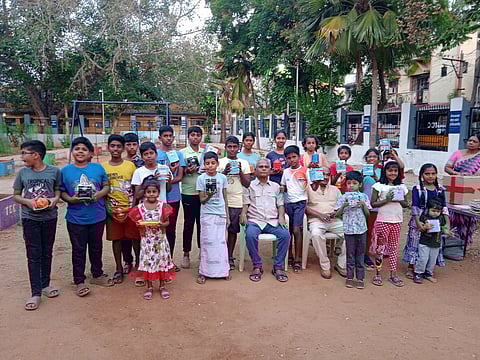 புத்தகம் படிக்கும் பழக்கம் மற்றும் சேமிப்பு பழக்கத்தை ஊக்கப்படுத்த வழங்கப்பட்ட உண்டியல்களுடன் மாணவ, மாணவியர்கள்.