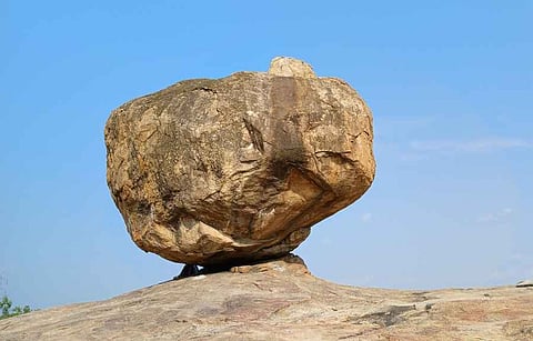 மீனாட்சிபுரம் அருகே குன்றத்தூா் மலையில் நிற்கும் அதிசய வானிறை பாறை.