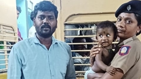 சேலம் ரயில்வே போலீஸாரிடம் குழந்தையை ஒப்படைத்த இளைஞா் வீரமணி.