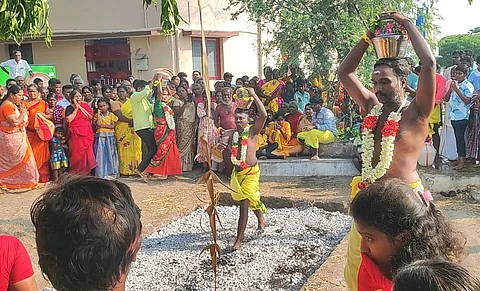 அம்மன் கோவில் முன்பு அமைக்கப்பட்டிருந்த தீ குண்டத்தில் இறங்கி நேர்த்திக்கடன் செலுத்தும் பக்தர்கள்,