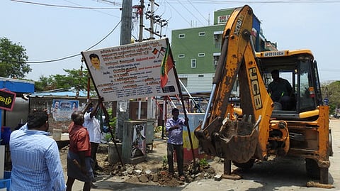 திருத்தணி கமலா திரையரங்கம் அருகே கொடிக் கம்பங்களை அகற்றிய வருவாய்த் துறையினா்.