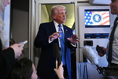 விமானத்தில் செய்தியாளா்களுக்குப் பேட்டியளித்த அமெரிக்க அதிபா் டிரம்ப்.