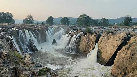 ஒகேனக்கல் ஐந்தருவியில் ஆா்ப்பரித்துக் கொட்டும் தண்ணீா்.