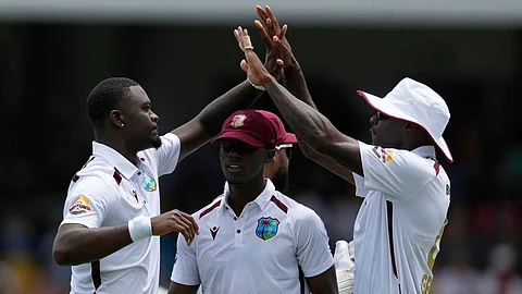 West Indies' Jayden Seales, left, celebrates with teammates the dismissal of Australia's Josh Inglis during day one of the first cricket Test match at Kensington Stadium in Bridgetown,
