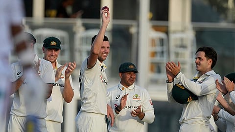 Australia's Josh Hazlewood raises the ball after taking the wicket of West Indies' Jomel Warrican, his fifth of the innings,