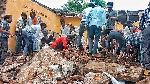 இடிந்து விழுந்த அரசுப்பள்ளி கட்டடத்தில் மீட்பு பணியில் ஈடுபட்ட உள்ளூர்வாசிகள்.