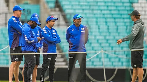 India's head coach Gautam Gambhir and support staff interact with a groundsman during a training session